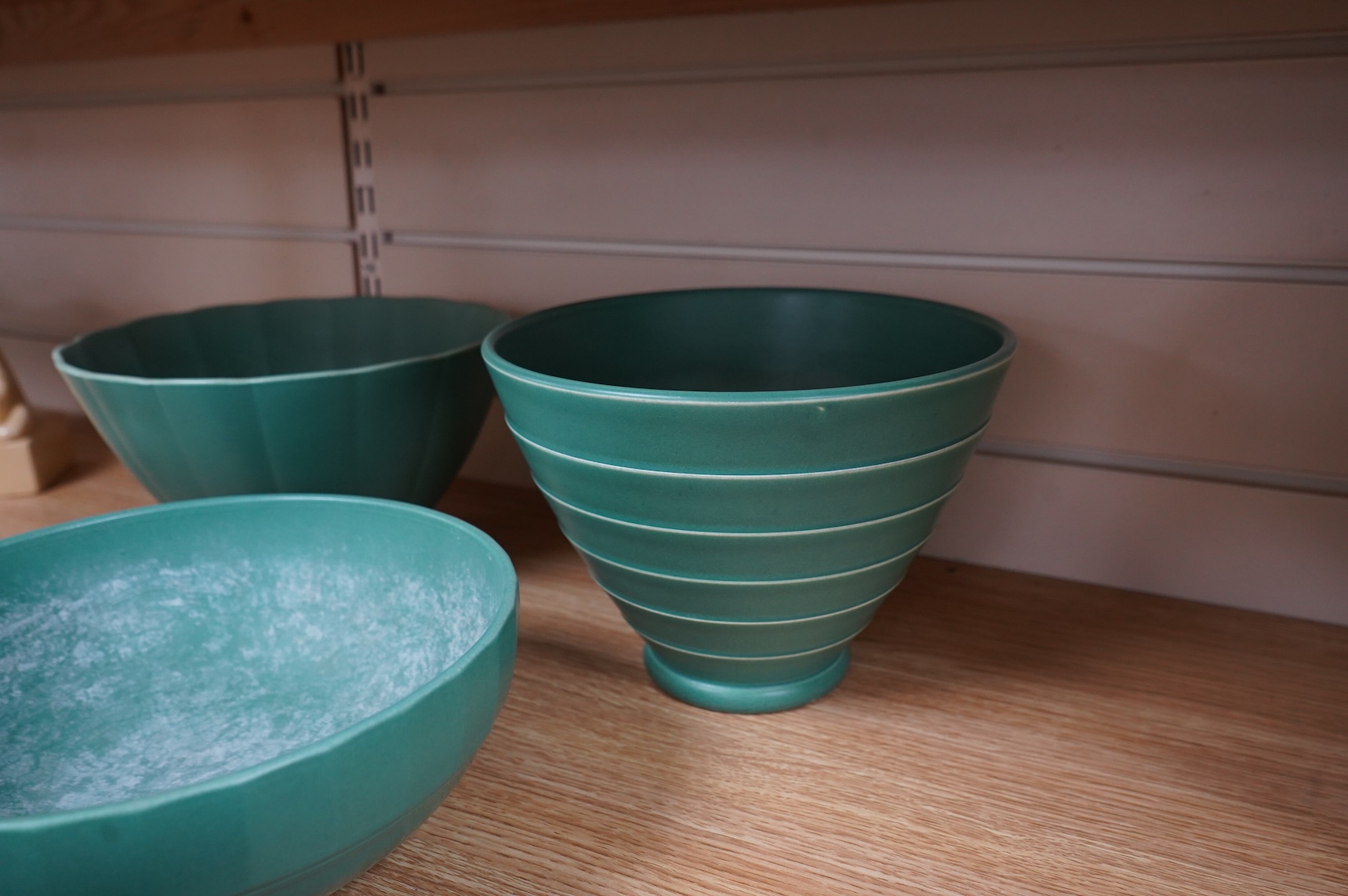 Keith Murray for Wedgwood, three green glazed bowls to include a ribbed example, largest 24cm in diameter